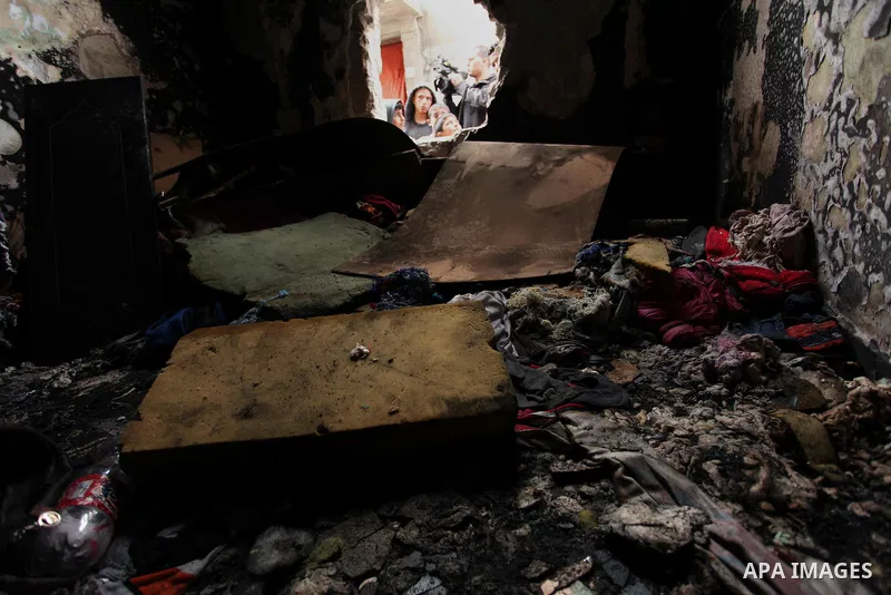 Palestinian children look through the window of burnt house after a candle caused a fire at the al-Hendi family's home at the al-Shati refugee camp in Gaza City on May 7, 2016. Photo by Ashraf Amra