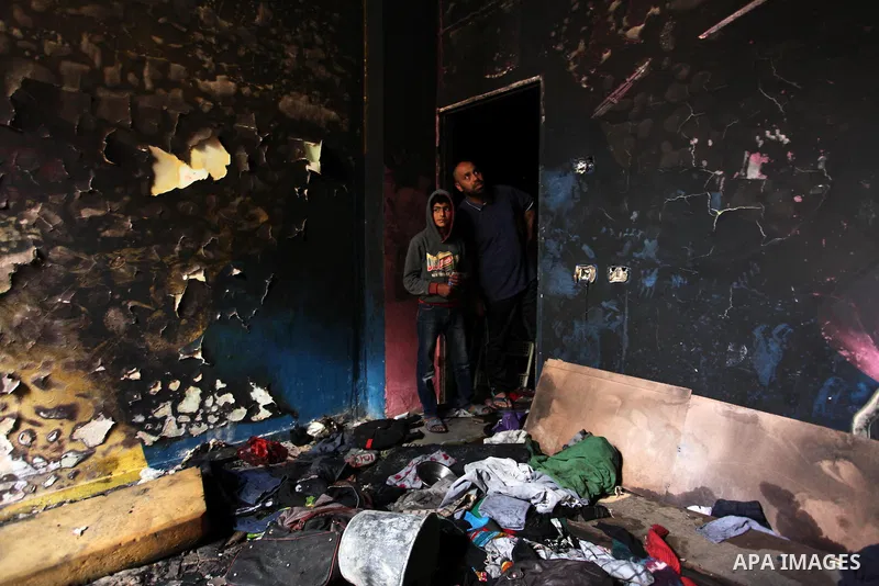 Palestinians look at the charred walls of a house after a candle caused a fire at the al-Hendi family's home at the al-Shati refugee camp in Gaza City on May 7, 2016. Photo by Ashraf Amra