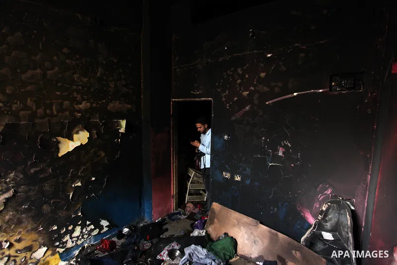 A Palestinian photographer take a photo for a torched house of al-Hendi family's after a candle caused a fire at the their house at the al-Shati refugee camp in Gaza City on May 7, 2016. Photo by Ashraf Amra