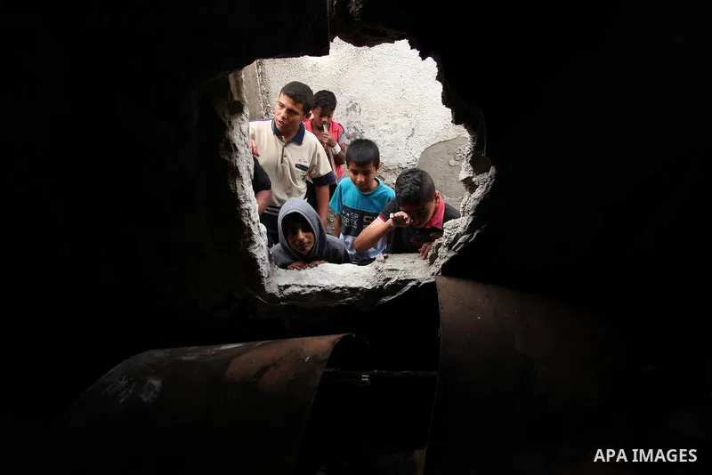 Palestinian children look through the window of burnt house after a candle caused a fire at the al-Hendi family's home at the al-Shati refugee camp in Gaza City on May 7, 2016. Photo by Ashraf Amra