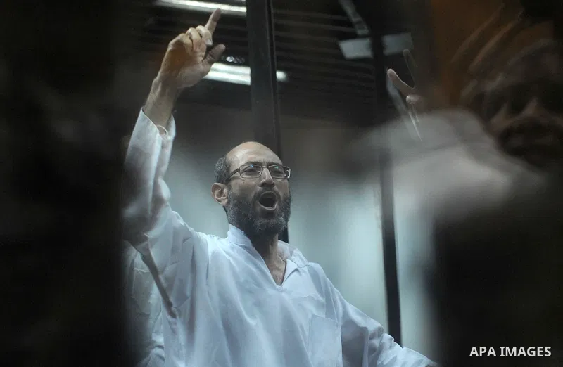 Defendants of Egyptian Muslim Brotherhood shot slogans from behind the defendant's bars during their trial at the police academy along with Egypt's ousted Islamist president Mohamed Morsi (unseen) in Cairo on May 7, 2016...
