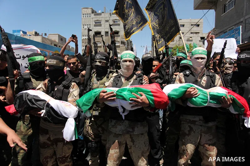 Members of the Ezzedine al-Qassam Brigades, the military wing of the Palestinian Islamist movement Hamas carry the bodies of three children from the al-Hindi family, who died in a fire caused by a candle at the family ho...