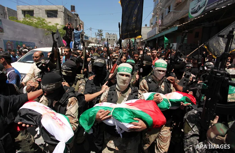 Members of the Ezzedine al-Qassam Brigades, the military wing of the Palestinian Islamist movement Hamas carry the bodies of three children from the al-Hindi family, who died in a fire caused by a candle at the family ho...