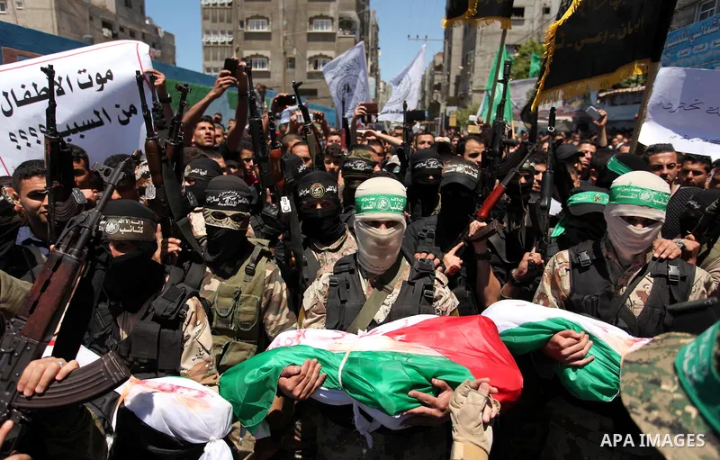 Members of the Ezzedine al-Qassam Brigades, the military wing of the Palestinian Islamist movement Hamas carry the bodies of three children from the al-Hindi family, who died in a fire caused by a candle at the family ho...