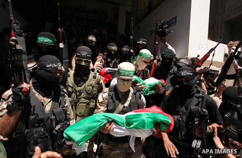 Members of the Ezzedine al-Qassam Brigades, the military wing of the Palestinian Islamist movement Hamas carry the bodies of three children from the al-Hindi family, who died in a fire caused by a candle at the family ho...