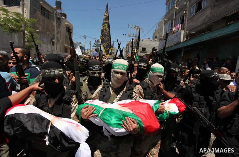 Members of the Ezzedine al-Qassam Brigades, the military wing of the Palestinian Islamist movement Hamas carry the bodies of three children from the al-Hindi family, who died in a fire caused by a candle at the family ho...