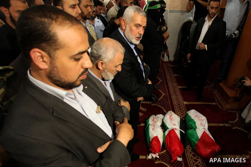 Palestinian mourners pray over the bodies of three children from the al-Hindi family, who died in a fire caused by a candle at the family home during their funeral at the al-Shati refugee camp in Gaza City on May 7, 2016...