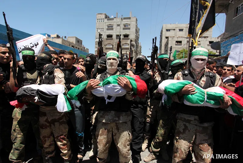 Members of the Ezzedine al-Qassam Brigades, the military wing of the Palestinian Islamist movement Hamas carry the bodies of three children from the al-Hindi family, who died in a fire caused by a candle at the family ho...