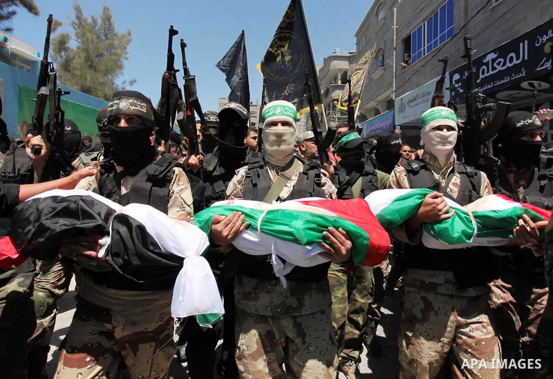 Members of the Ezzedine al-Qassam Brigades, the military wing of the Palestinian Islamist movement Hamas carry the bodies of three children from the al-Hindi family, who died in a fire caused by a candle at the family ho...