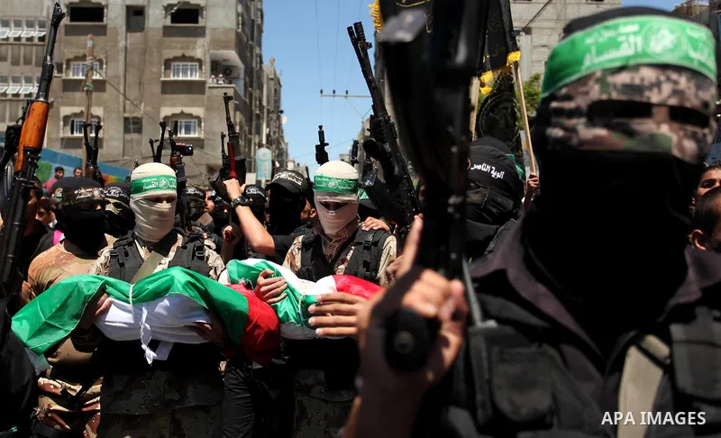 Members of the Ezzedine al-Qassam Brigades, the military wing of the Palestinian Islamist movement Hamas carry the bodies of three children from the al-Hindi family, who died in a fire caused by a candle at the family ho...