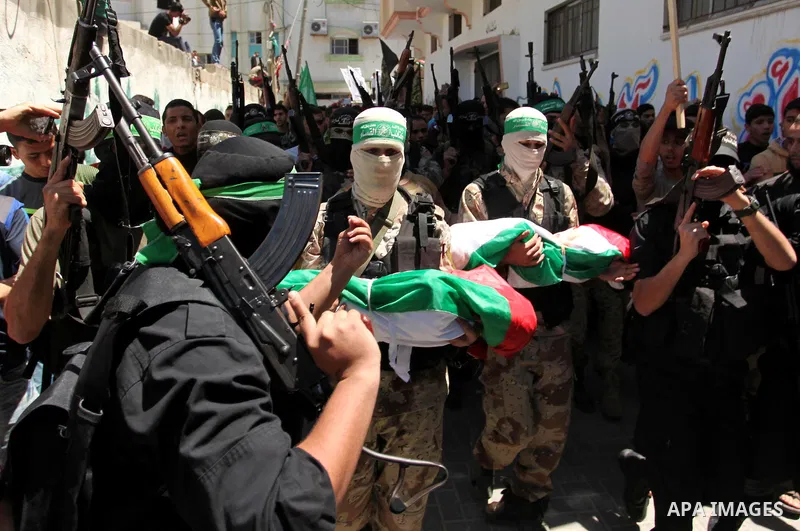 Members of the Ezzedine al-Qassam Brigades, the military wing of the Palestinian Islamist movement Hamas carry the bodies of three children from the al-Hindi family, who died in a fire caused by a candle at the family ho...