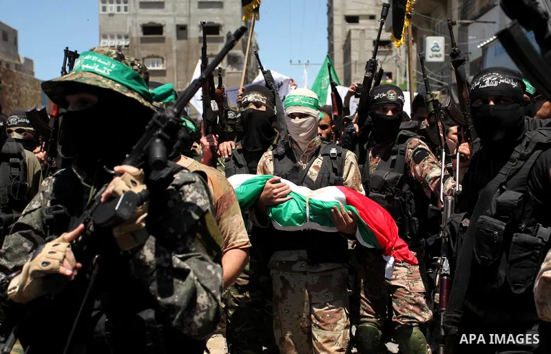 Members of the Ezzedine al-Qassam Brigades, the military wing of the Palestinian Islamist movement Hamas carry the bodies of three children from the al-Hindi family, who died in a fire caused by a candle at the family ho...