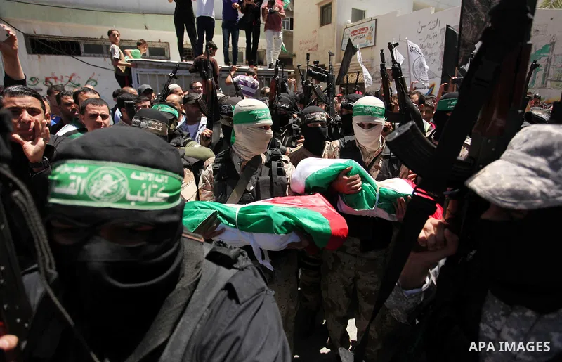 Members of the Ezzedine al-Qassam Brigades, the military wing of the Palestinian Islamist movement Hamas carry the bodies of three children from the al-Hindi family, who died in a fire caused by a candle at the family ho...