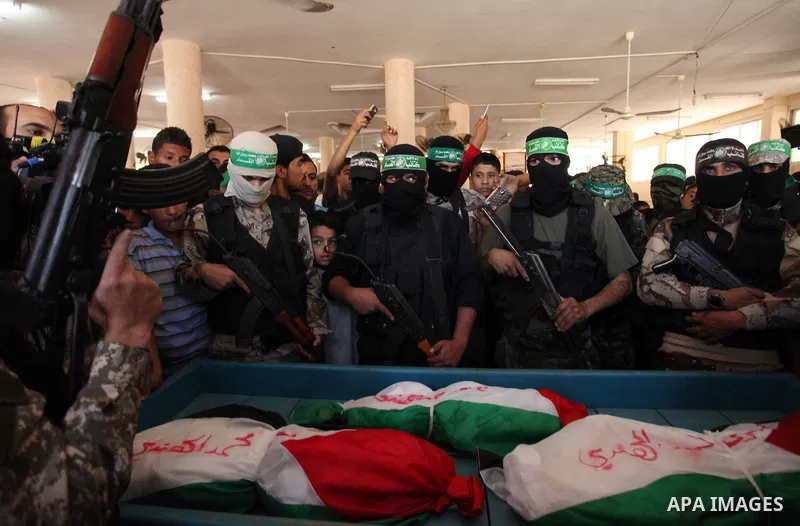 Palestinian Islamist movement Hamas' chief, Ismail Haniya mourns next to the bodies of three children from the al-Hindi family, who died in a fire caused by a candle at the family home at the al-Shati refugee camp in Gaz...
