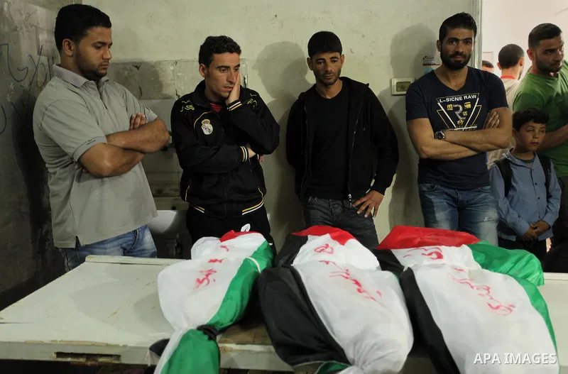 Palestinian relatives of three children from the al-Hindi family who died in a fire caused by a candle at the family home, mourn next to their bodies at al-Shifa hospital in Gaza City on May 7, 2016. Photo by Ashraf Amra