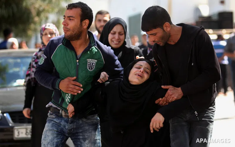 The mother of the al-Hindi family mourns during the funeral of three of her sons who died in a fire caused by a candle at the family home, at the al-Shati refugee camp in Gaza City on May 7, 2016. Photo by Ashraf Amra