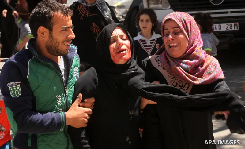 The mother of the al-Hindi family mourns during the funeral of three of her sons who died in a fire caused by a candle at the family home, at the al-Shati refugee camp in Gaza City on May 7, 2016. Photo by Ashraf Amra