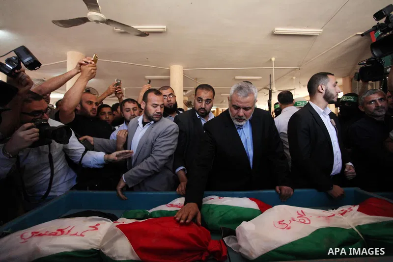 Palestinian Islamist movement Hamas' chief, Ismail Haniya mourns next to the bodies of three children from the al-Hindi family, who died in a fire caused by a candle at the family home at the al-Shati refugee camp in Gaz...