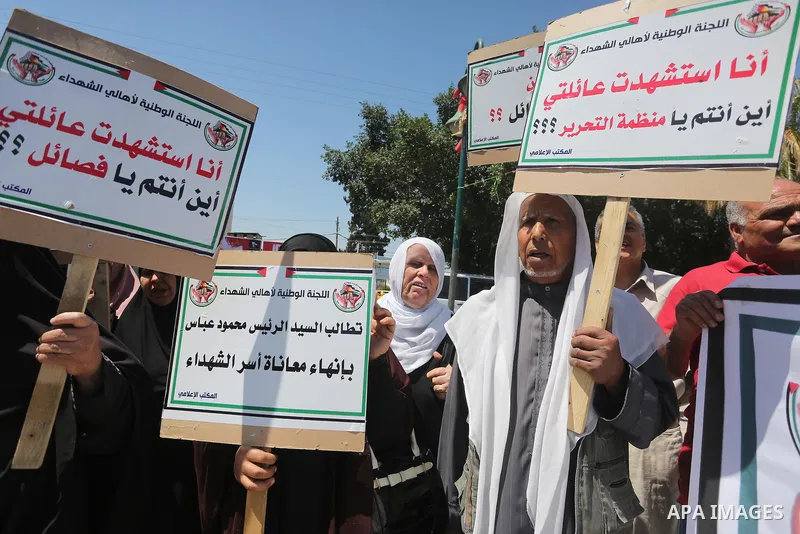 Palestinians hold placards during a protest against a power cut and the Israeli blockade of the Gaza Strip, in Gaza city on May 8, 2016. Photo by Mohammed Asad