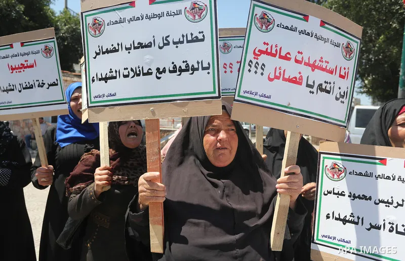 Palestinians hold placards during a protest against a power cut and the Israeli blockade of the Gaza Strip, in Gaza city on May 8, 2016. Photo by Mohammed Asad