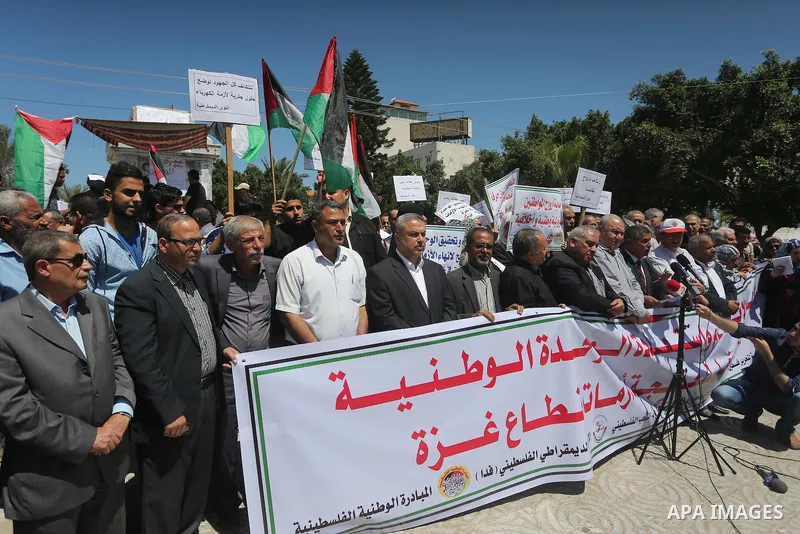 Palestinians hold placards during a protest against a power cut and the Israeli blockade of the Gaza Strip, in Gaza city on May 8, 2016. Photo by Mohammed Asad