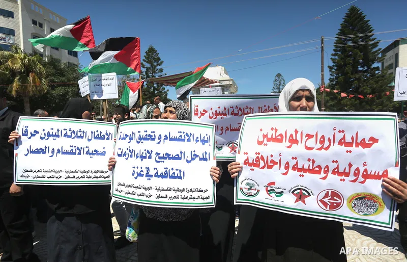 Palestinians hold placards during a protest against a power cut and the Israeli blockade of the Gaza Strip, in Gaza city on May 8, 2016. Photo by Mohammed Asad