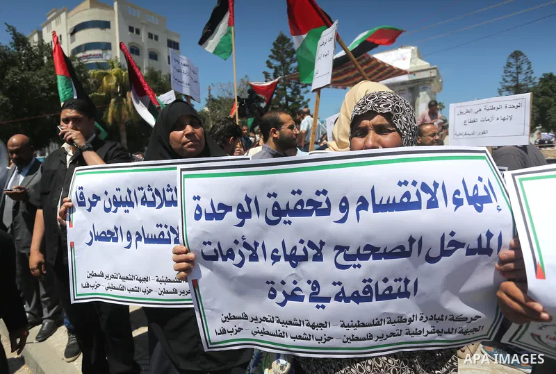 Palestinians hold placards during a protest against a power cut and the Israeli blockade of the Gaza Strip, in Gaza city on May 8, 2016. Photo by Mohammed Asad