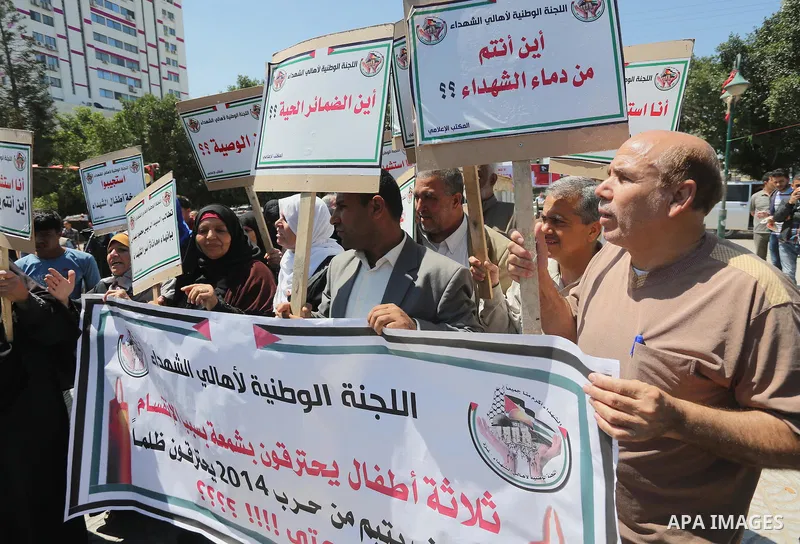 Palestinians hold placards during a protest against a power cut and the Israeli blockade of the Gaza Strip, in Gaza city on May 8, 2016. Photo by Mohammed Asad