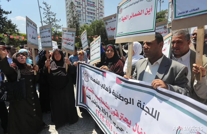 Palestinians hold placards during a protest against a power cut and the Israeli blockade of the Gaza Strip, in Gaza city on May 8, 2016. Photo by Mohammed Asad