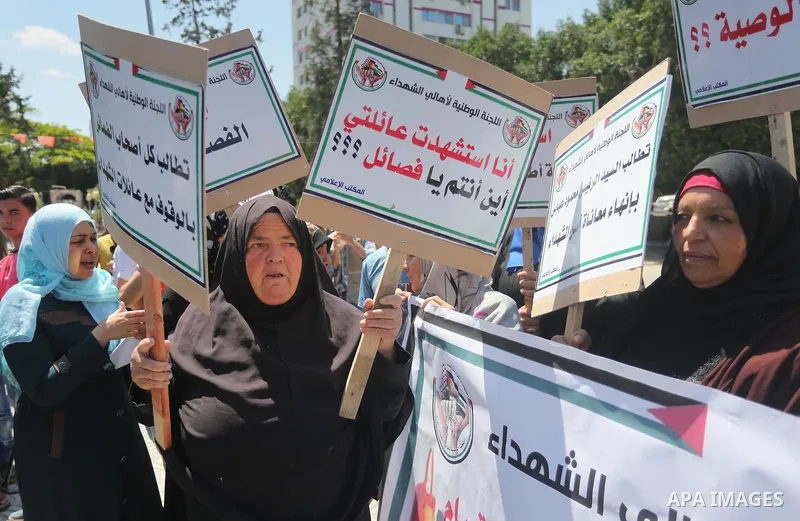 Palestinians hold placards during a protest against a power cut and the Israeli blockade of the Gaza Strip, in Gaza city on May 8, 2016. Photo by Mohammed Asad