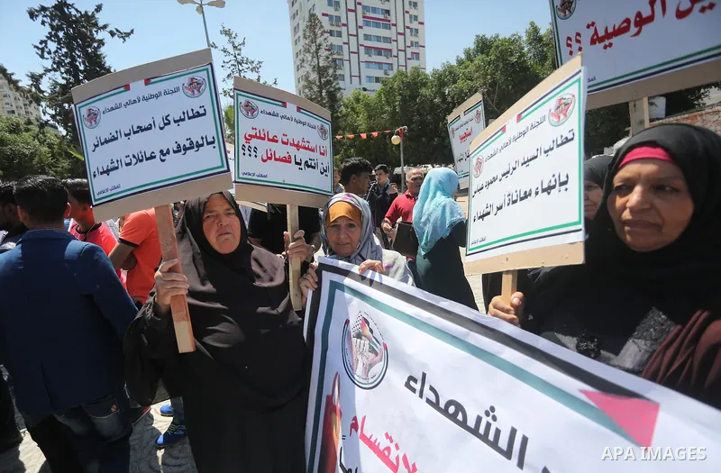 Palestinians hold placards during a protest against a power cut and the Israeli blockade of the Gaza Strip, in Gaza city on May 8, 2016. Photo by Mohammed Asad