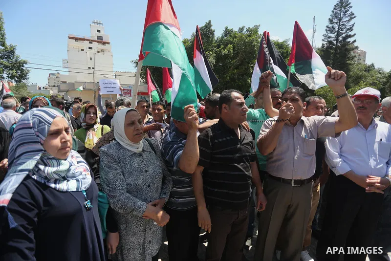 Palestinians hold placards during a protest against a power cut and the Israeli blockade of the Gaza Strip, in Gaza city on May 8, 2016. Photo by Mohammed Asad