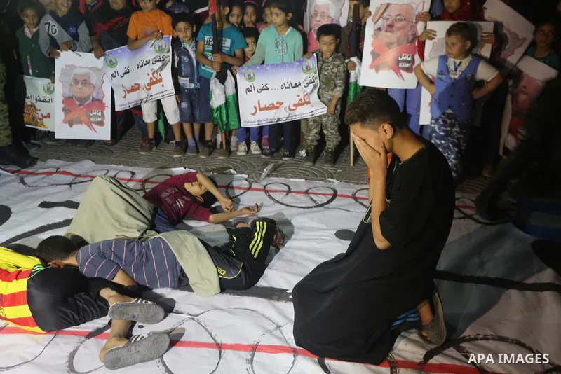 Palestinian children hold placards during a protest demanding for end the siege on Gaza and against the killing of three boys from the al-Hindi family, who died in a fire caused by a candle at the family home in Gaza cit...