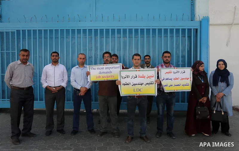 Palestinian engineers hold banners during a protest against the UNRWA decision to reduce of the work contracts in front of the headquarters United Nations Relief and Works Agency (UNRWA) in Gaza city, on May 9, 2016. Pho...