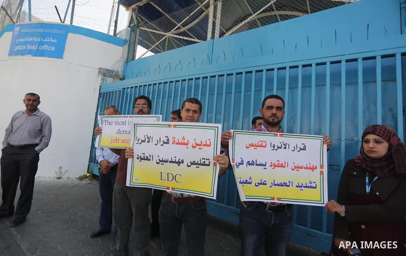 Palestinian engineers hold banners during a protest against the UNRWA decision to reduce of the work contracts in front of the headquarters United Nations Relief and Works Agency (UNRWA) in Gaza city, on May 9, 2016. Pho...