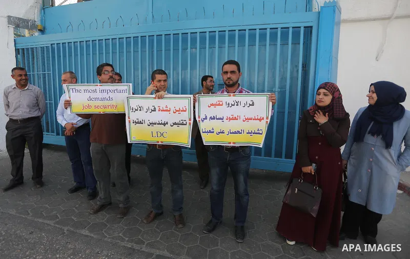 Palestinian engineers hold banners during a protest against the UNRWA decision to reduce of the work contracts in front of the headquarters United Nations Relief and Works Agency (UNRWA) in Gaza city, on May 9, 2016. Pho...