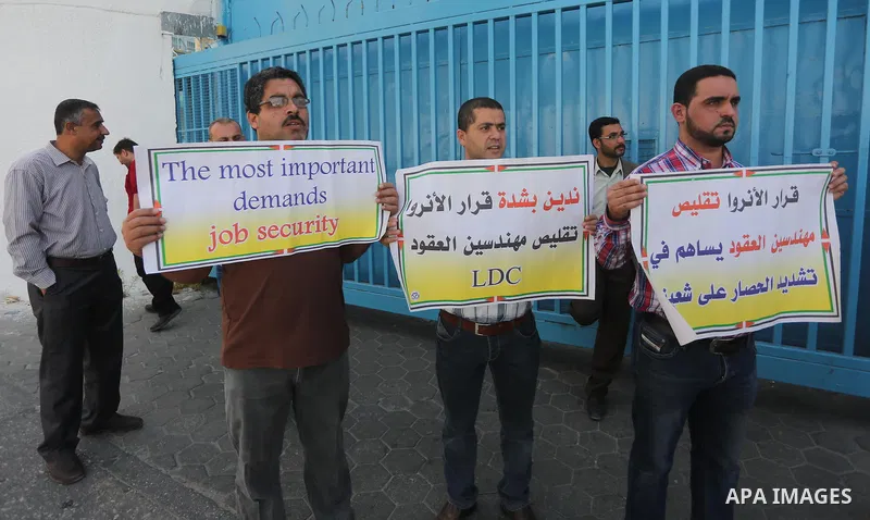 Palestinian engineers hold banners during a protest against the UNRWA decision to reduce of the work contracts in front of the headquarters United Nations Relief and Works Agency (UNRWA) in Gaza city, on May 9, 2016. Pho...