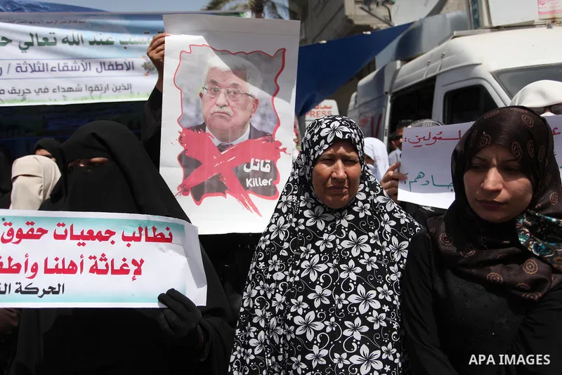 Palestinian children hold placards during a protest against the killing of three boys from the al-Hindi family, who died in a fire caused by a candle at the family home in Gaza city on May 9, 2016. Photo by Ashraf Amra