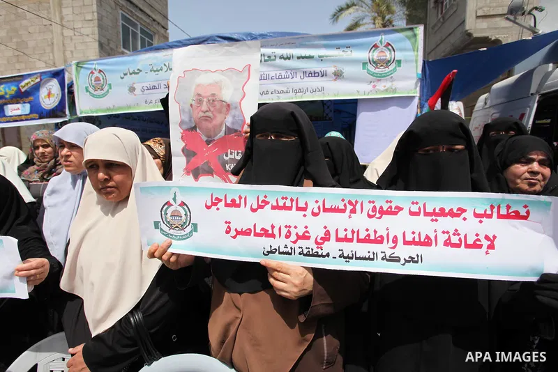 Palestinian children hold placards during a protest against the killing of three boys from the al-Hindi family, who died in a fire caused by a candle at the family home in Gaza city on May 9, 2016. Photo by Ashraf Amra