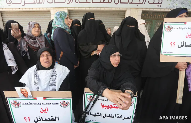 Palestinian families of martyrs, hold banners during a protest to demand their salaries, in Gaza city, on May 10, 2016. Photo by Mohammed Asad