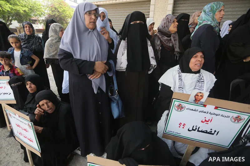 Palestinian families of martyrs, hold banners during a protest to demand their salaries, in Gaza city, on May 10, 2016. Photo by Mohammed Asad