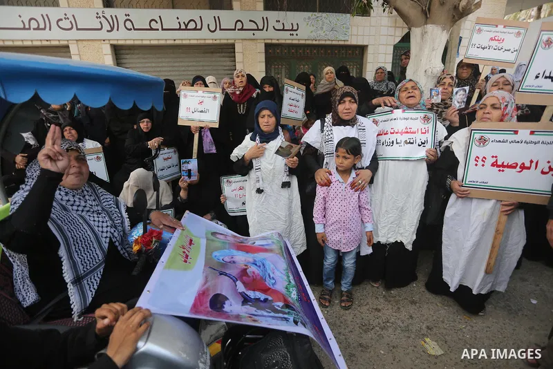 Palestinian families of martyrs, hold banners during a protest to demand their salaries, in Gaza city, on May 10, 2016. Photo by Mohammed Asad