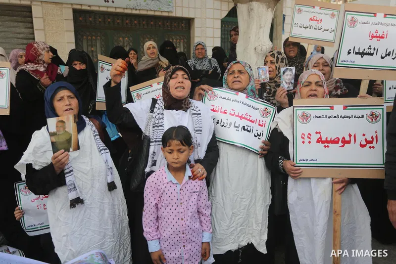 Palestinian families of martyrs, hold banners during a protest to demand their salaries, in Gaza city, on May 10, 2016. Photo by Mohammed Asad