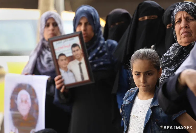 Palestinian families of martyrs, hold banners during a protest to demand their salaries, in Gaza city, on May 10, 2016. Photo by Mohammed Asad