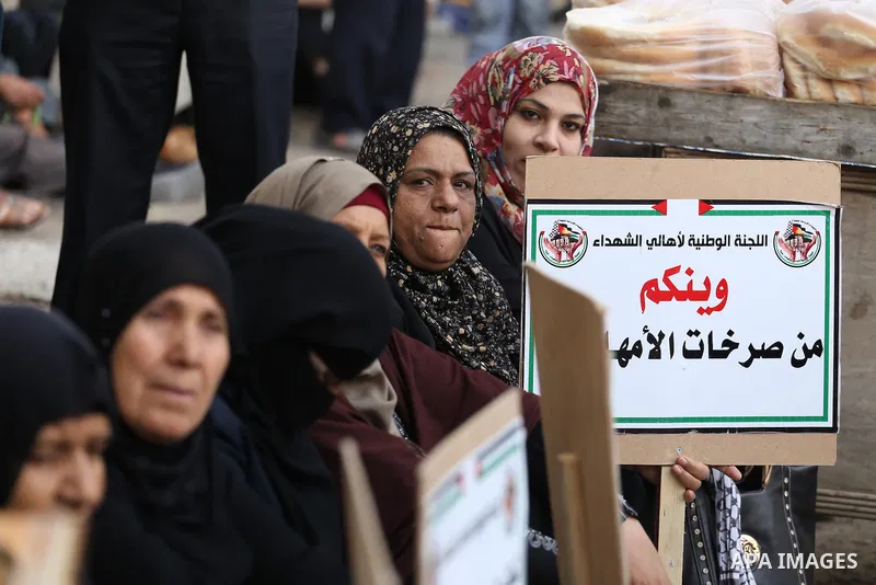 Palestinian families of martyrs, hold banners during a protest to demand their salaries, in Gaza city, on May 10, 2016. Photo by Mohammed Asad