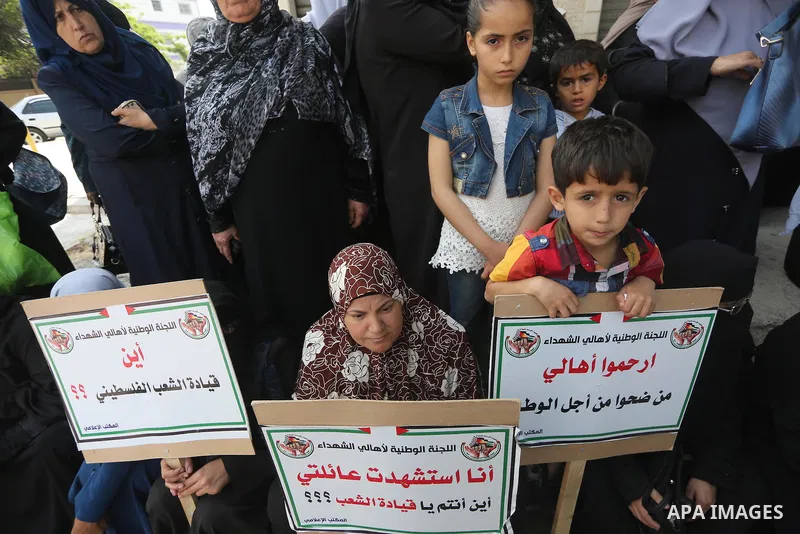 Palestinian families of martyrs, hold banners during a protest to demand their salaries, in Gaza city, on May 10, 2016. Photo by Mohammed Asad