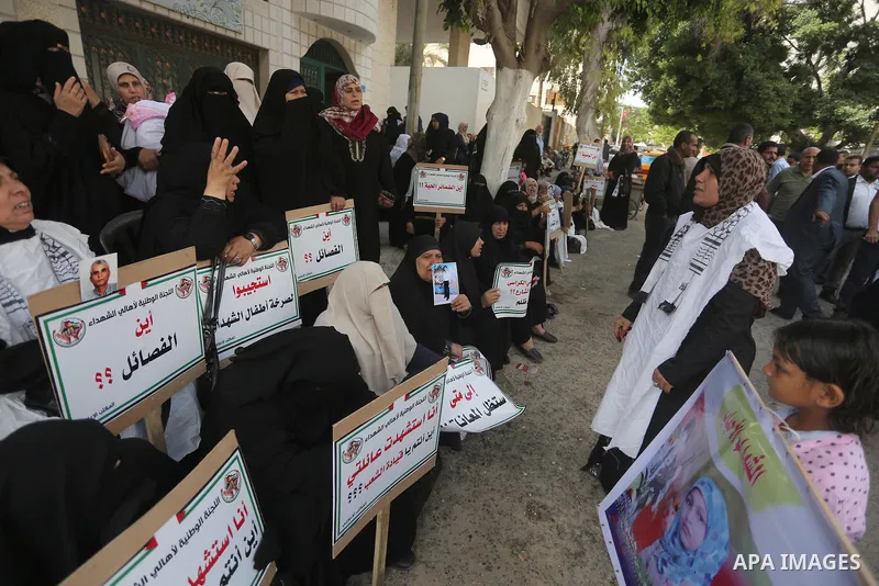 Palestinian families of martyrs, hold banners during a protest to demand their salaries, in Gaza city, on May 10, 2016. Photo by Mohammed Asad