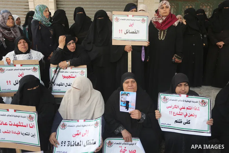 Palestinian families of martyrs, hold banners during a protest to demand their salaries, in Gaza city, on May 10, 2016. Photo by Mohammed Asad