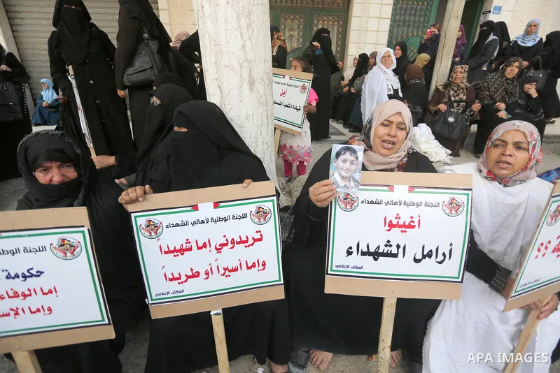 Palestinian families of martyrs, hold banners during a protest to demand their salaries, in Gaza city, on May 10, 2016. Photo by Mohammed Asad