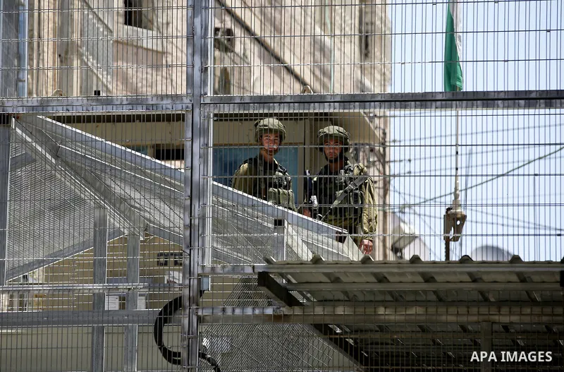 Israeli security forces take position during a protest against the closure of Shuhada street to Palestinians in the West Bank city of Hebron on May 12, 2016. Photo by Wisam Hashlamoun